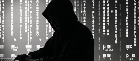 Image portrays a Matrixinspired hackers silhouette wearing a hoodie with distinctive patterns photo