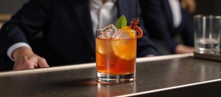 A cocktail glass filled with an alcoholic beverage sits on a bar table at a nightclub or restaurant photo