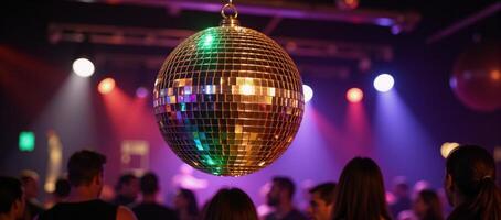 Glowing disco ball illuminates club dance floor with vibrant rainbows photo