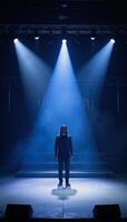 Free stage bathed in darkness accented by dramatic blue spotlights for an enigmatic presentation or performance backdrop photo