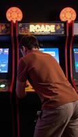 Retro arcade setting featuring a man playing classic games with a vintage feel photo
