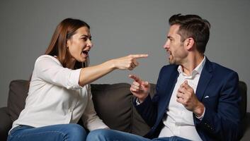 Married couple engages in a heated argument on their couch with the aggressive wife pointing fingers at her unyielding spouse photo