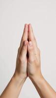 Closeup image of female hands in prayer pose against a pure white background photo
