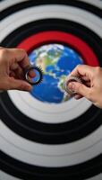 Hands manipulating mechanical parts positioned over Earth as focal point photo