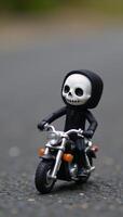 Small skullheaded humanoid figure on a flameadorned miniature motorbike photo