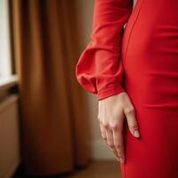 Woman in red dress with longsleeved top and raised arm exudes warmth and comfort photo