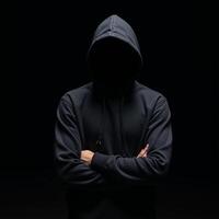 A lone figure dressed in a hooded sweatshirt stands amidst darkness and blurred shadows photo