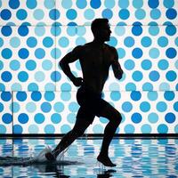 Man runs amidst dotfilled background portrayed as if submerged in water photo