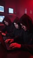 Three anonymous hackers work undercover amidst a red eerie foggy ambiance photo