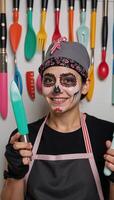 A Sugar Skull chef is depicted wearing a bandana while wielding kitchen utensils photo