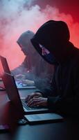 Three cloaked figures hack anonymously within a sinister digital lair photo