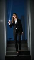 A comprehensive career guide offers guidance on stepping up in your career and achieving success illustrated by a flashlights beam illuminating the way forward on a businesswomans climb to the top photo
