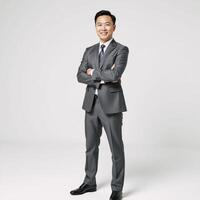 Portrait of an Asian businessman in a grey suit exuding confidence and friendliness against a purewhite backdrop photo