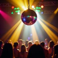A disco ball illuminates the dancefloor with rainbow beams and swirling bokeh lights behind photo