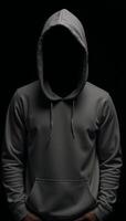 A lone figure dressed in a hooded sweatshirt stands amidst darkness and blurred shadows photo