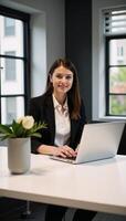 A stylish businesswoman works productively at her desk with laptop computer in a modern office setting photo