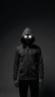 A hooded figure with glowing eyes against a dark backdrop photo