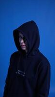 Hooded figure against blue backdrop photo