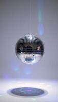 A discoball sphere glows brightly against a pristine white backdrop photo