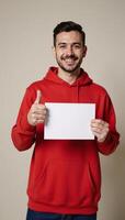 Man in red hoodie holds paper with thumbsup gesture photo