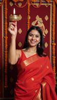 A Diwaliclad Indian girl holds a festival of lights candle in traditional attire photo