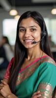 Closeup portrait of an Indian customer service representative wearing a headset at their desk to represent the concept of support services photo