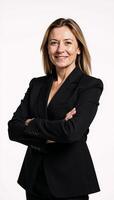 A professional businesswoman stands confidently against an isolating white backdrop dressed in a black suit with crossed arms photo