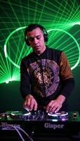 Illustrated image showcasing a DJ wearing headphones amidst pulsating laser light effects at a nightclub photo