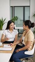 Multicultural female mentor advising trainee on business matters in office setting photo