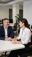 Senior financial expert mentors young woman in collaborative setting within contemporary office space photo