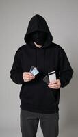 A hooded male figure represents phishing scams and password thefts photo