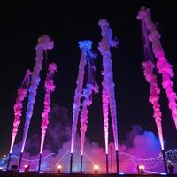 Vibrant nighttime light spectacle amidst an atmospheric backdrop of colored smoky effects photo