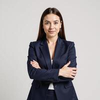 Businesswoman portrait against a clean white backdrop with crossed arms wearing professional attire photo