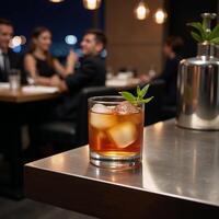 A cocktail glass filled with an alcoholic beverage sits on a bar table at a nightclub or restaurant photo