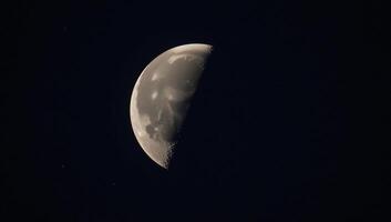 A detailed depiction of the moons rugged surface illuminated by stars against a night sky photo