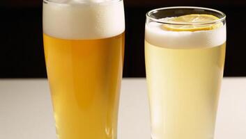 A Hefeweizen glass holds a hazy golden beer while another is garnished photo
