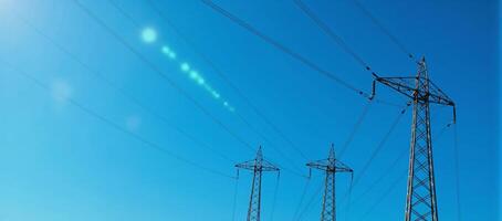 Green Energy Concept Blue glow on highvoltage transmission towers against a blue sky photo
