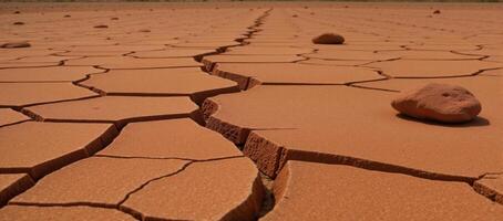 Craggy weathered landscape featuring cracked red soil and strewn rocks photo