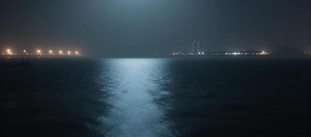 A foggy dock on still dark water at night photo
