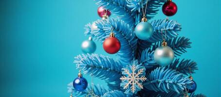 Blue Christmas tree adorned with snowflakes and baubles against a blue backdrop photo