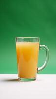Apple juice in a handled glass set against a pristine white backdrop photo