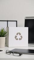 Office scene with white box displaying recycling symbol photo