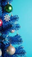 Blue Christmas tree adorned with snowflakes and baubles against a blue backdrop photo