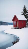 A winter wonderland scene featuring a cozy red cabin by a frozen lake evoking tranquility and escape photo