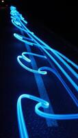 Blue trail lights paint dynamic curved patterns along the winding road photo