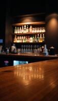 Blurry neon lights illuminate a woodtopped bar table photo