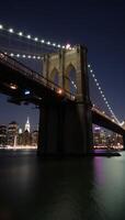 Nighttime scene featuring Brooklyn Bridge illuminated against the city skyline photo