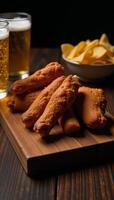Fried chicken wings beer nachos served on a wooden board in shadowy silhouette photo