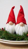 Festive Thanksgiving table features two Christmasthemed gnome figurines wearing red hats surrounded by pine and holly decorations photo