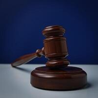 Wooden gavel resting on a blue table against a dark blue backdrop symbolizes law justice and legal matters photo